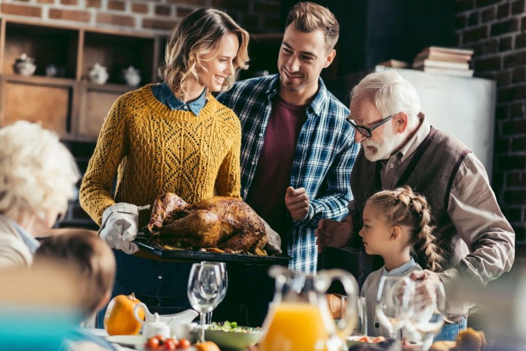 This picture shows two parents, two grandparents, and one child in the kitchen working to prepare a turkey. It symbols the attainment of family harmony.
