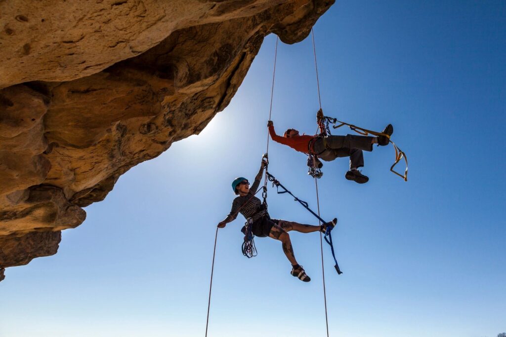 This picture shows two rock climbers in all their gear tangling off a rock cliff. It symbolizes personal fulfillment.